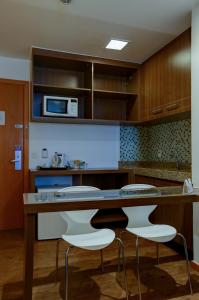 a kitchen with a wooden table and chairs at Nobile Suites Monumental in Brasília