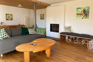 ein Wohnzimmer mit einem Sofa und einem Tisch in der Unterkunft Nachhaltiges Wohnen in Seenähe in Schömberg