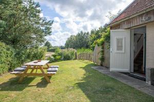 a picnic table in the grass next to a building at Eendrachtweg 4 in De Cocksdorp