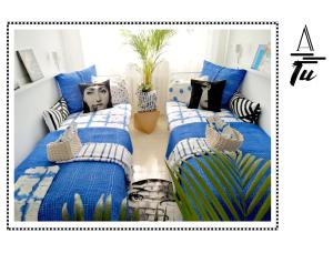 two beds in a room with blue and white pillows at A morze TU in Gdynia