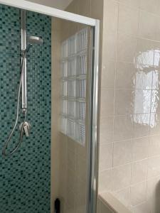 una doccia con porta in vetro in bagno di Casa Vacanze Pesce Palla a Villaggio Azzurro