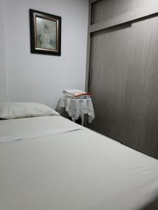 a bedroom with a bed with a door and a table at Apartamento completo medellin in Medellín