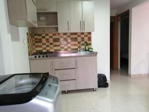 a kitchen with a sink and a stove top oven at Apartamento completo medellin in Medellín