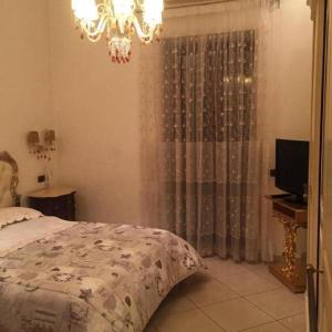 1 dormitorio con cama y lámpara de araña en Napoli Forever, en Nápoles