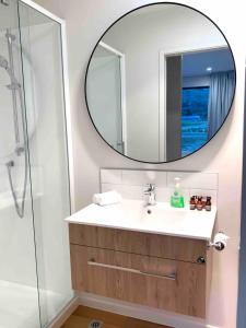 uma casa de banho com um lavatório e um espelho em Hillside Studio em Queenstown
