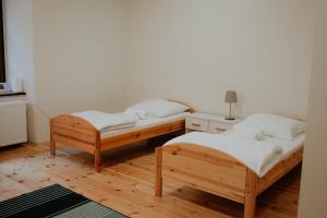 two beds in a room with wooden floors at Zamkowa, Pokoje Gościnne in Kazimierz Dolny