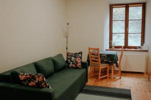 a living room with a green couch and a table at Zamkowa, Pokoje Gościnne in Kazimierz Dolny