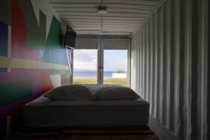 a bed in a room with a large window at Nomada Republic Hotel Punta Chame in Punta Chame