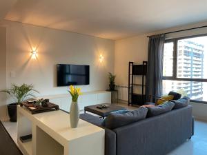 uma sala de estar com um sofá e uma televisão em ABC Expo Apartment em Lisboa