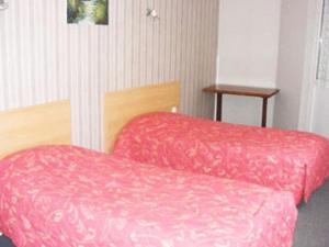 - 2 lits avec des couvertures rouges dans une chambre dans l'établissement Le Trianon, à Hesdin