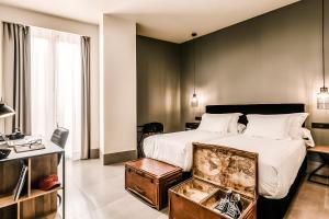 a hotel room with a bed and a desk and a room at HO Puerta de Purchena in Almería