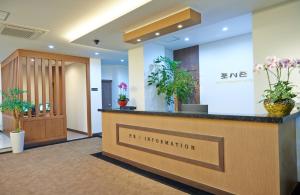 an office lobby with a reception desk and plants at Hotel Four Seasons in Jeju