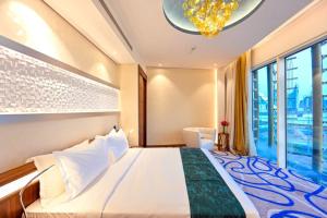 a bedroom with a large bed and a large window at Cielo Hotel Lusail Qatar in Doha