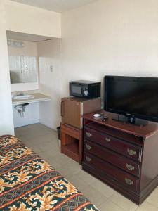 um quarto de hotel com uma cama e uma televisão de ecrã plano em Surfside Motel - Seaside Heights em Seaside Heights