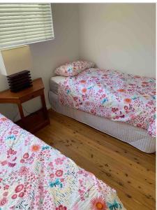 a bedroom with two beds and a table with a lamp at 2 Bed Bar Beach Apartment - stroll to beach & cafes, supermarket apartment number 6 in Newcastle