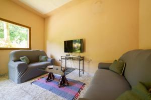 - un salon avec deux canapés et une télévision dans l'établissement Casa de Família (Campo), à Parati