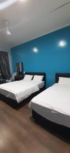 twee bedden in een kamer met een blauwe muur bij THE CLOUD KINABALU- Chalet in Ranau