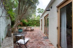 a patio with chairs and tables next to a building at Soloman Street Cottage in Fremantle