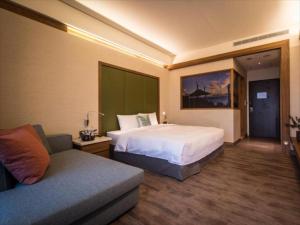 Habitación de hotel con cama y sofá en Taroko Liiko Hotels en Xincheng