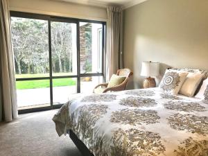 a bedroom with a bed and a large window at Road Sun Tourist Lodge in Dunedin