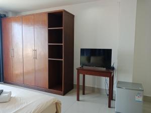 a bedroom with a tv and a desk with a bed at Baanpak Sam Anong in Hua Hin