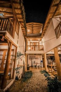 a large building with wooden ceilings and a patio at Ganso & Búho in Ayampe
