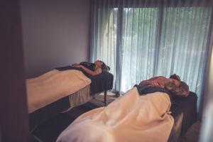 two beds sitting next to a window in a room at Amaroo Retreat & Spa in Mount Helena
