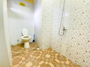 a bathroom with a toilet and a shower at Damigalova Guest House Mitra RedDoorz in Jambi