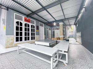 a room with two white benches in a building at Damigalova Guest House Mitra RedDoorz in Jambi