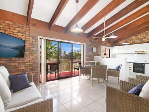 a kitchen and living room with a brick wall at Coral Gardens Unit 2 in Coolangatta