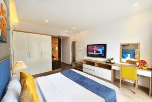 a hotel room with a television and a bed at Amorita Boutique Hotel Hanoi in Hanoi
