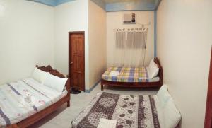een kleine kamer met 2 bedden en een raam bij RBR HOTEL AND RESTAURANT in Lucap