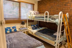 a room with two bunk beds and a brick wall at Holiday Home in the Heart of Anglesea in Anglesea
