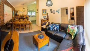 a living room with a leather couch and a table at Holiday Home in the Heart of Anglesea in Anglesea