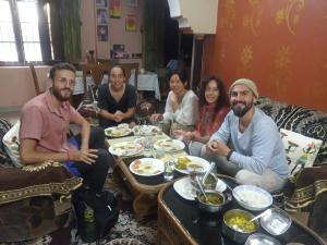 a group of people sitting around a table eating food at Gungun Homestay in Rishīkesh +19 photos