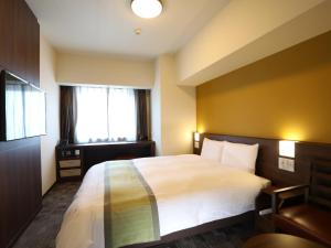 a hotel room with a bed and a window at Dormy Inn Ikebukuro in Tokyo