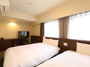 Dormy Inn Ikebukuro客房内的一张或多张床位