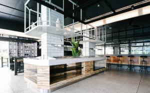 a lobby with a counter with chairs and tables at BOOK Design HOTEL -SHA Extra Plus in Chiang Mai