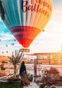 a woman walking in front of a hot air balloon at Kelebek Special Cave Hotel & Spa in Göreme