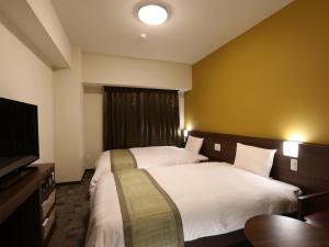 Dormy Inn Ikebukuro客房内的一张或多张床位