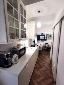 cocina con armarios blancos, fregadero y microondas en Apartamenty Orkana, en Bielsko-Biala