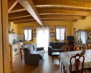 a living room with a couch and a table and chairs at El Mirador del Bierzo in Tedejo