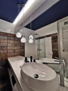 a bathroom with a white sink and a tub at Apartamenty Orkana in Bielsko-Biala