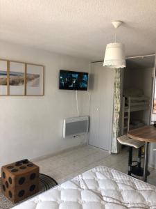 ein Schlafzimmer mit einem Bett und ein Zimmer mit einem TV in der Unterkunft Studio cabine Toi et Moi à 30 m de la plage de Valras centre in Valras-Plage