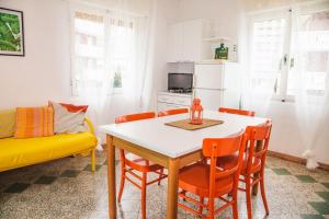 cocina y comedor con mesa y sillas en Casa Zanelli, en Lignano Sabbiadoro