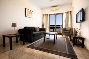a living room with a couch and a tv at Pigeon Beach Hotel Apartments in Limassol