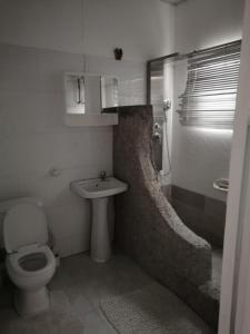 a bathroom with a toilet and a sink at Tricia Gardens - One family home in Spintex