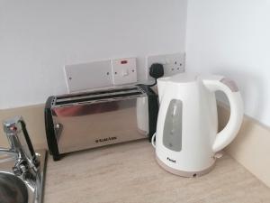 a white coffee maker next to a toaster oven at LAOUTARIS INN in Panayia