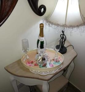 Una botella de champán y dos copas en una mesa. en LAOUTARIS INN, en Panayia