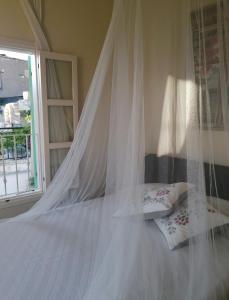 uma cama branca com um dossel e uma janela em LAOUTARIS INN em Panayia